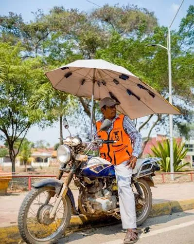 Conductor de motocicleta trabajando junto a su vehículo en Riberalta